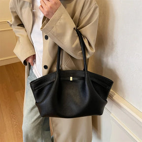 Bolsa tote Oxford preta feminina em couro usada em look moderno